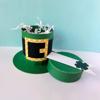 Green leprechaun hat craft filled with shredded paper on white surface