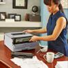 Woman replacing toner cartridge in Brother monochrome laser printer at home office desk