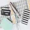 Labeled personal items including luggage tag, water bottle, and pen on patterned background