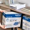 Brother TN-750 high-yield toner cartridge twin pack held in home office workspace