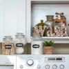 Brother all-in-one printer with control panel on white countertop beneath organized kitchen shelves