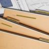 Organized wooden desk with fabric swatches, blueprints, and color samples for interior design