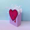 Purple gift bag with red heart and key decoration filled with white tissue paper