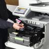 Person replacing magenta toner cartridge in Brother all-in-one printer with touchscreen display