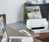 Brother compact document scanner on desk scanning colorful infographic about renewable energy data