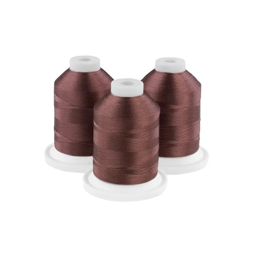 Three coffee bean brown embroidery thread spools on white bases