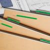 Organized file folders with green labels and fabric swatches on desk