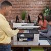 Man scanning document on Brother all-in-one printer in modern office workspace