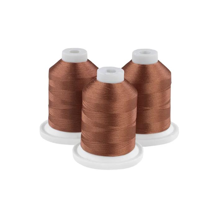 Three cocoa brown embroidery thread spools on white bases