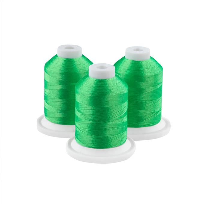 Three neon green embroidery thread spools with white caps on circular bases