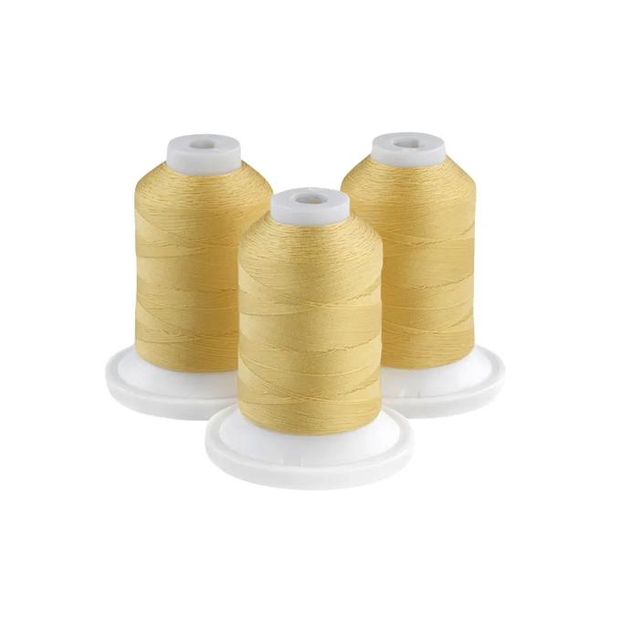 Three lemon yellow embroidery thread spools on white bases