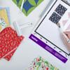 Brother cutting mat with colorful fabric swatches and quilting tools on white surface