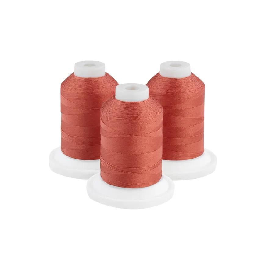 Three dark rust embroidery thread spools on white bases