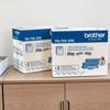 Brother TN-750 high-yield toner cartridge twin pack on wooden cabinet