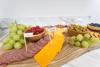 Charcuterie board with labeled cheddar, salami, grapes, olives, raspberries, and crackers