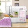 Brother sewing machine with floral design panel stitching purple fabric on wooden table