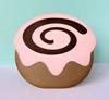 Pink frosted donut with chocolate swirl decoration on pastel background