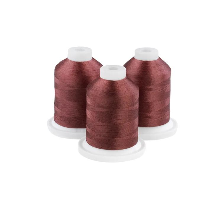 Three brownstone embroidery thread spools on white bases