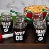 Personalized game day mason jars with striped straws and football graphics on wooden tray