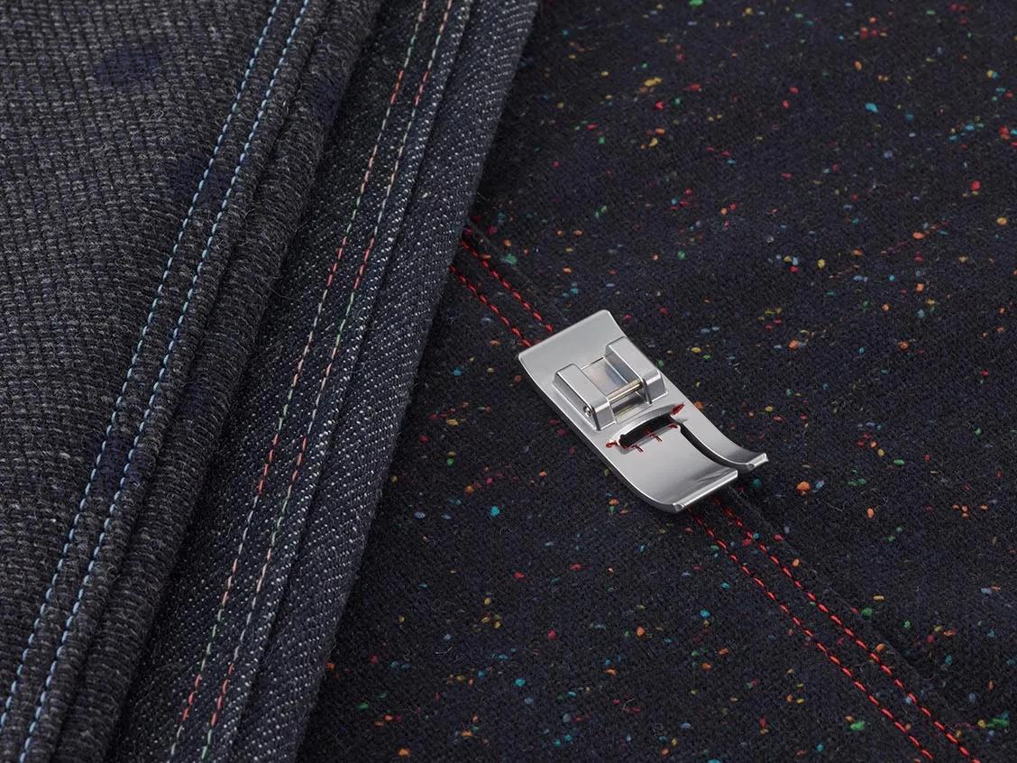 Brother sewing machine presser foot on black fabric with colorful decorative stitching