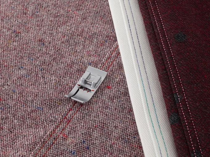 Brother sewing machine presser foot creating decorative stitches on multicolored fabric