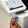 Hand inserting blue USB drive into Brother MFC all-in-one color laser printer with touchscreen