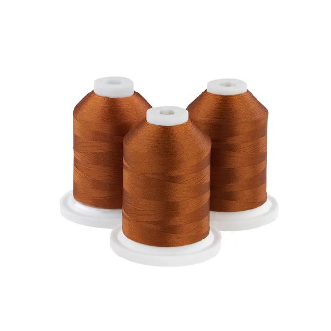 Three hazelnut-colored embroidery thread spools on white bases
