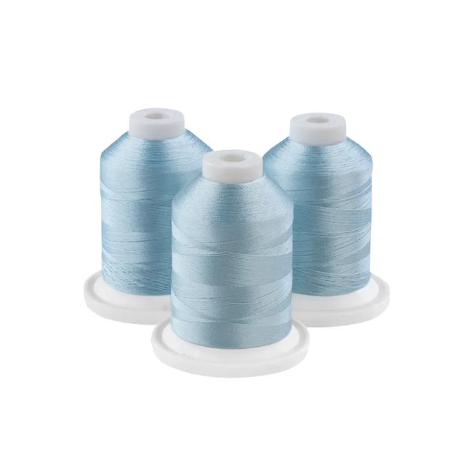 Three sky blue embroidery thread spools on white bases