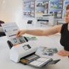 Brother ADS-3350W wireless desktop scanner scanning invoices and photos on office desk