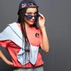 Woman wearing blue sunglasses and cap with Brother character patch on coral shirt