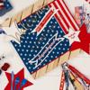 Patriotic yard sign with stars and stripes design surrounded by red, white, and blue craft supplies