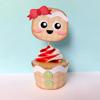 Gingerbread character cupcake topper with red bow and swirled frosting