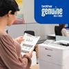 Woman reviewing document printed on Brother laser printer in modern office with genuine ink signage