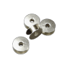 Four metal sewing machine bobbins on black background