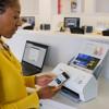 Woman using Brother wireless document scanner with smartphone in modern office environment