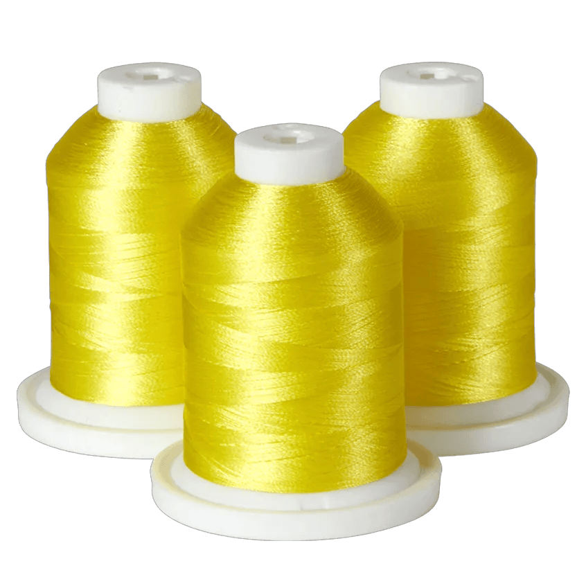 Three spools of bright yellow Brother embroidery thread on white bases