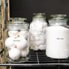 Brother TZe-121 label on glass jar with cotton balls in organized bathroom storage