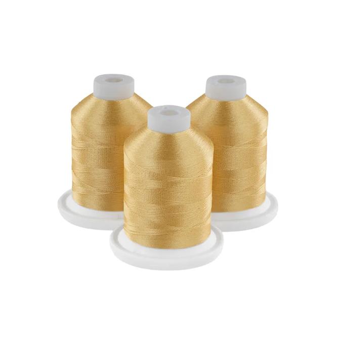 Three golden embroidery thread spools with white caps on circular bases
