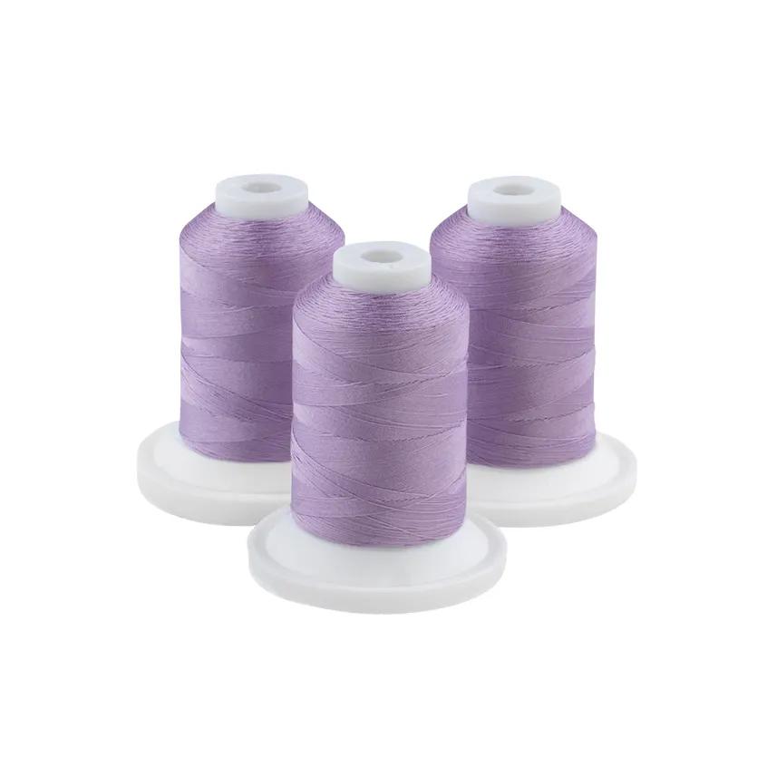 Three spools of mild purple embroidery thread on white bases