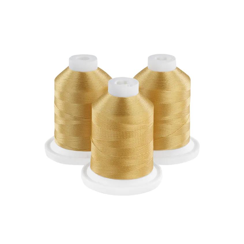 Three golden embroidery thread spools on white bases
