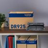 Brother DR925 drum unit displayed with packaging on wooden shelf