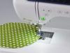 Brother sewing machine stitching curved seam on green polka dot fabric