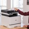 Person scanning document on Brother MFC-L8730CDW color laser all-in-one printer in office