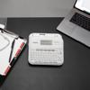 Brother P-touch portable label maker with QWERTY keyboard on office desk with laptop and clipboard