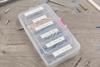 Labeled organizer box with sorted screws on wooden surface