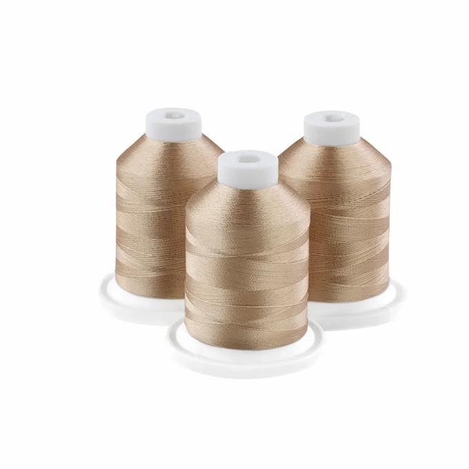 Three caramel-colored embroidery thread spools on white bases