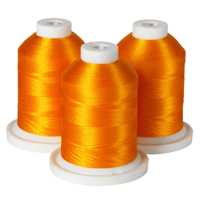 Three spools of vibrant orange embroidery thread on white bases