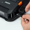 Hand connecting USB cable to Brother portable printer with orange release lever