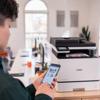 Person using smartphone to print with Brother MFC-L8730CDW wireless color laser all-in-one printer