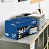 Brother TN660 high-yield toner cartridge 2-pack on shelf beside laser printer